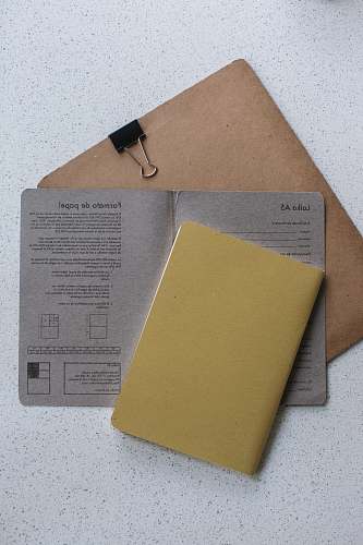 file binder yellow softbound book on grey printer paper file folder